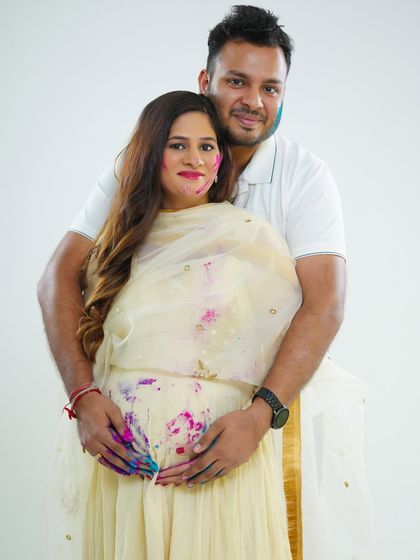 A warm and happy portrait of the couple embracing. The splashes of color on their clothes and faces add a unique and festive touch to this classic maternity pose.