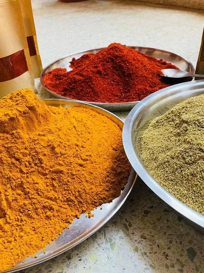 The secret to authentic flavor is in the spices. I source these vibrant, hand-ground masalas directly from Rajasthan. You can see the rich color and texture of the turmeric, red chili, and coriander powders.