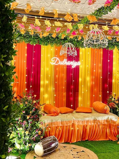A lively Dholki setup for the bride-to-be. The colorful drapes and 'Dulhaniya' neon sign set the stage for a night of music, laughter, and celebration.