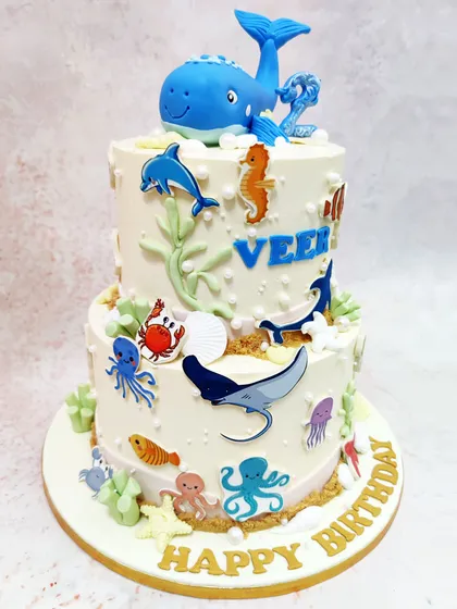 We dive deep into imagination with this two-tiered underwater adventure cake. Topped with a magnificent whale and adorned with a variety of sea creatures like dolphins, seahorses, and crabs, this design highlights our skill in creating detailed, multi-layered aquatic scenes.