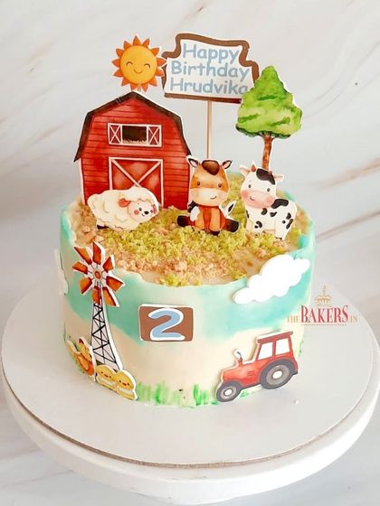 A charming farm animal cake for a 2nd birthday celebration. This no-fondant cake features a barn, windmill, and cute farm animals like a horse, cow, and sheep. The flavor was vanilla with mixed berries.