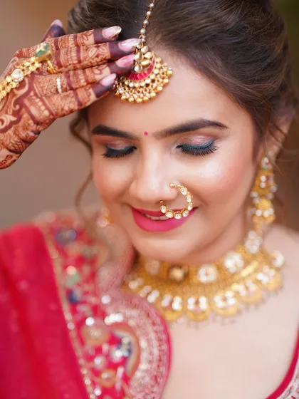 A pop of color on the eyes! We added a hint of teal liner to complement her red lehenga, adding a modern twist to her traditional look.