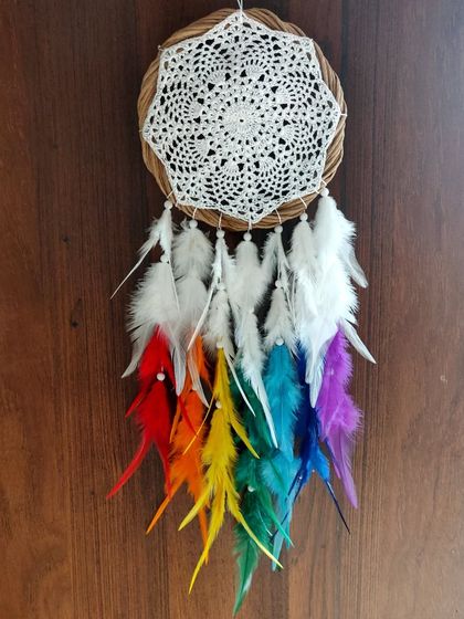 Rainbow dreams and magical delights. Let this vibrant rainbow dreamcatcher with a classic crochet web and colorful feathers bring joy and brightness to your space.