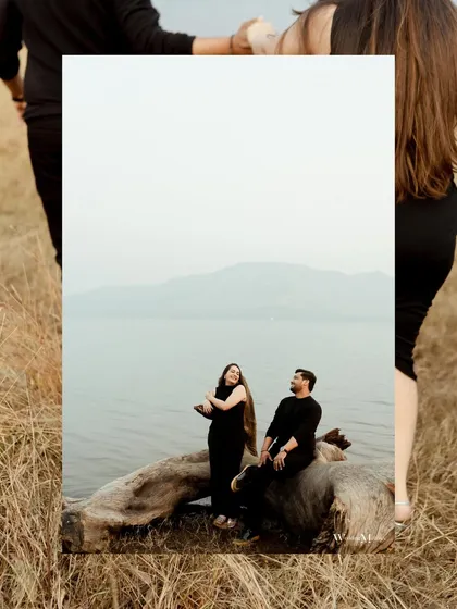 A creative composition framing a candid moment. The foreground and background elements create a sense of looking in on a private, happy interaction between the couple.