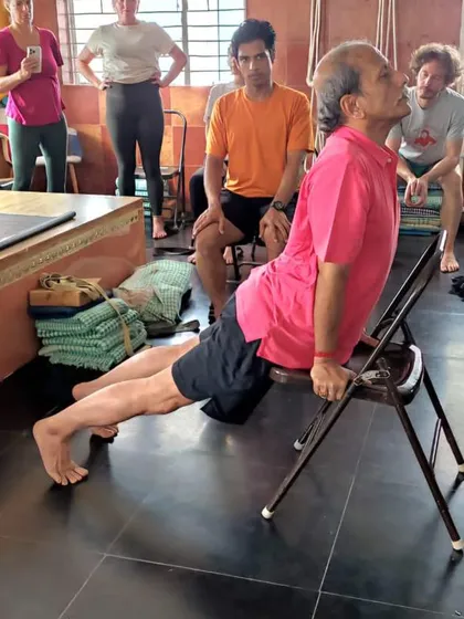 A demonstration of Purvottanasana (Upward Plank Pose) using a chair. This variation builds upper body and core strength while opening the chest.