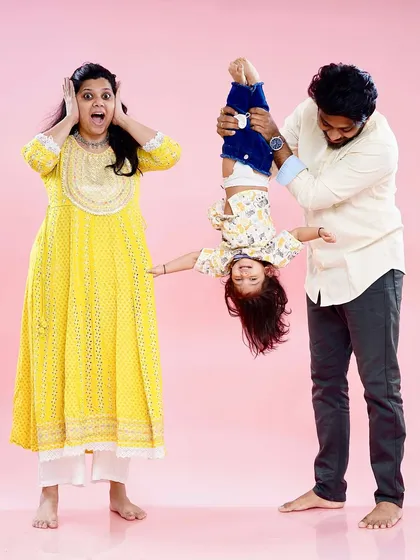 Sometimes the most memorable family photos are the silliest ones. We love capturing the fun, chaotic, and real moments that define your family's unique personality, like this playful studio shot.