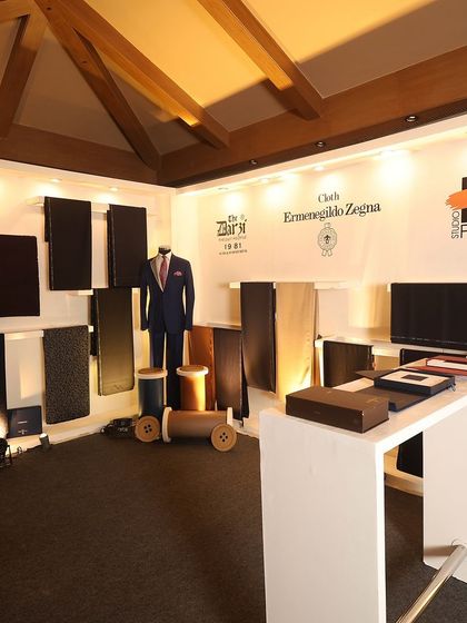 Our curated display for the Ermenegildo Zegna fabric launch event. The setup showcases a selection of exclusive Italian fabrics and a mannequin dressed in a bespoke navy suit, representing the fusion of fine materials and expert tailoring.