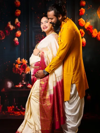 Capturing the loving bond in a traditional setting. This couple's portrait is full of warmth, with their ethnic outfits shining against the festive decor of our studio.