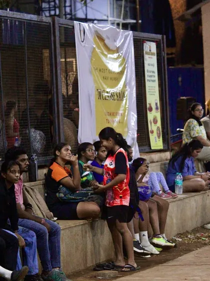 Players resting on the sidelines, watching the other games and supporting their peers.