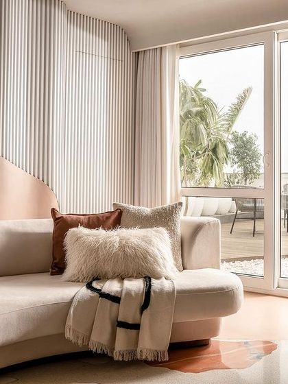 A detail shot of the living room sofa, with plush cushions and a view of the outdoor terrace.