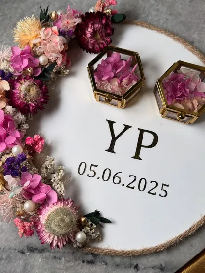 This 'Platter da Flora' ring tray has a rustic feel with its jute rope border and a vibrant crescent of dried flowers. The couple's initials and date are personalized in the center.