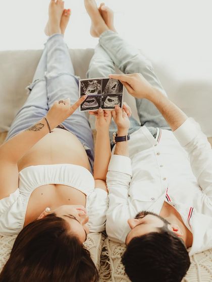 A creative and intimate shot of the couple looking at their sonogram pictures together. This unique perspective captures a private and meaningful moment.