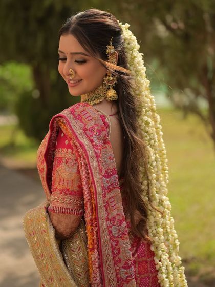 This shot captures the full effect of the bride's stunning hair and makeup. The soft waves and floral trail are perfectly balanced by a radiant, dewy makeup look.