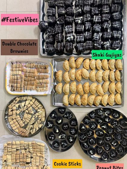 A festive collection of sweets and baked goods, including Double Chocolate Brownies, Shahi Gujiyas, Cookie Sticks, and Peanut Bites. Something for everyone in one frame.