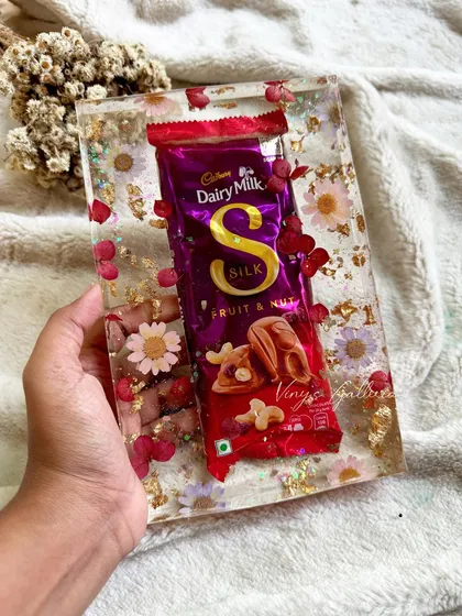 Sometimes, the most unique memories come in the sweetest packages. A client asked me to preserve a Dairy Milk Silk bar from a cherished moment, and I encased it in this dreamy floral resin block. It's a fun reminder that any special item can become a piece of art.