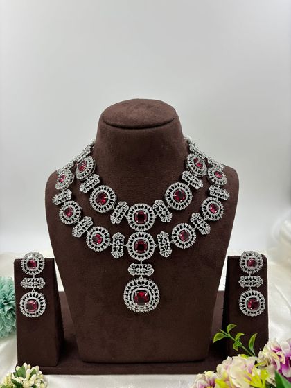 This bold, silver-plated AD set features large circular motifs. It's a statement piece available in sapphire blue, emerald green, ruby red, and all-white, perfect for customers who want to stand out.