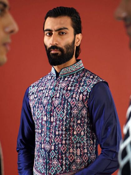 This Jawahar jacket showcases a complex, multi-colored geometric pattern, a testament to our intricate weaving and embroidery techniques. It is a bold and artistic choice for the discerning gentleman.