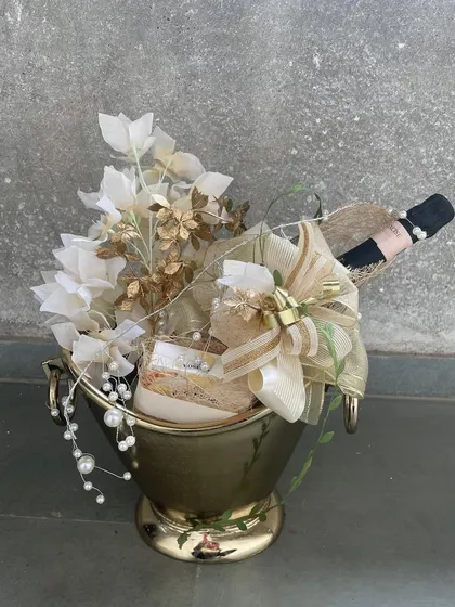 For the ultimate celebratory statement, we present our signature champagne bucket hamper. This opulent arrangement combines a bottle of fine champagne with elegant floral accents and other curated gifts, all presented in a reusable, decorative bucket.
