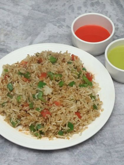 My Veg Fried Rice is a staple comfort food, cooked with finely chopped vegetables and seasoned perfectly. I serve it with classic red chilli and green chilli sauces so you can customize the spice to your liking.