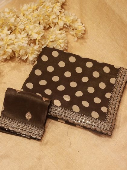 A playful yet chic tissue organza saree with large polka dots and an embroidered border, a modern choice for evening parties.