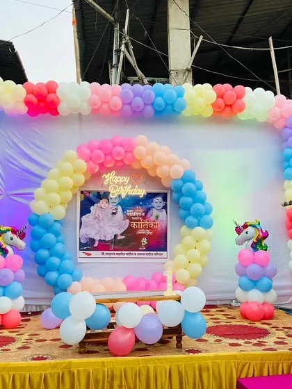 A wider view of the outdoor unicorn birthday party setup, showing the full stage and colorful decorations.