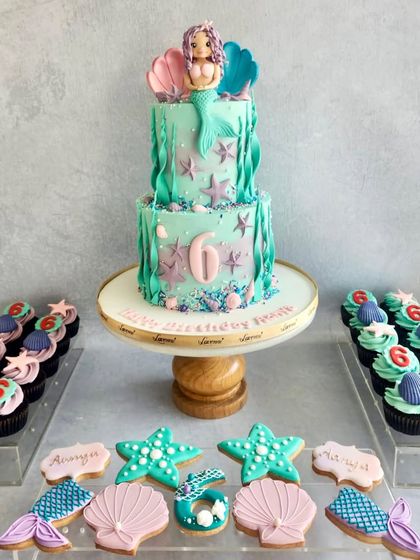 Another take on the mermaid theme, this time with a two-tiered cake and matching cookies and cupcakes. The colours and details bring the under-the-sea party to life.
