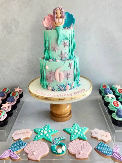 Another take on the mermaid theme, this time with a two-tiered cake and matching cookies and cupcakes. The colours and details bring the under-the-sea party to life.