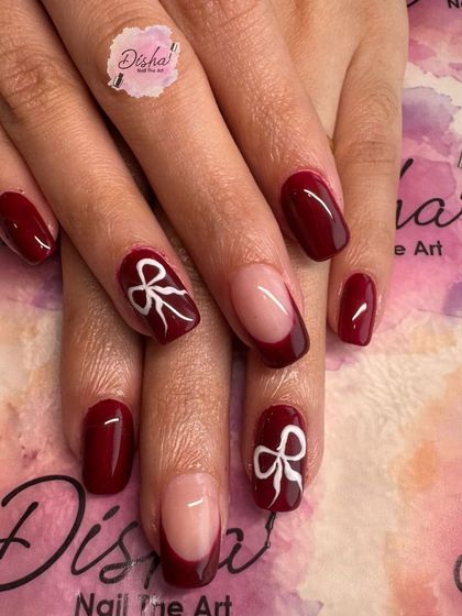 Fresh nails, fresh vibes. This design features a deep red base with cute, hand-painted white bows.
