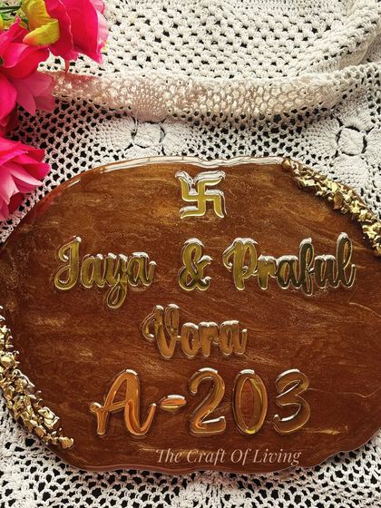 Welcome your guests with elegance. This custom resin nameplate features a rich, wood-like finish with golden acrylic lettering, creating a warm and inviting entrance.