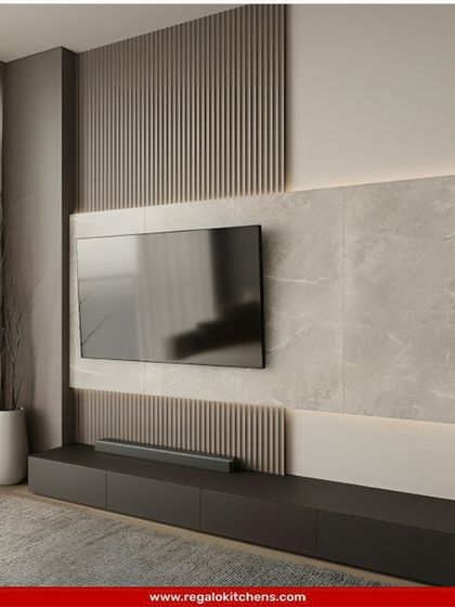 This design uses a mix of materials, including fluted panels and a smooth stone-like surface, to create a textured and visually interesting TV wall.