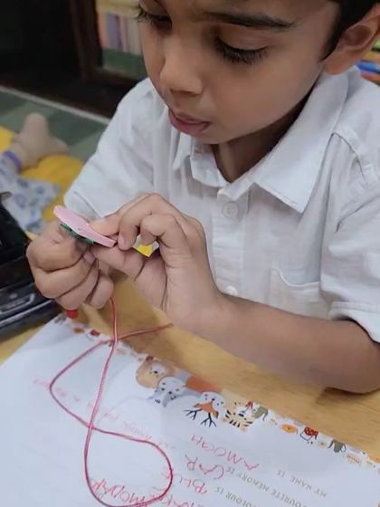 A young boy concentrates on a lacing craft activity. Our parties always include a mix of games and quiet, focused activities to suit different personalities and energy levels.