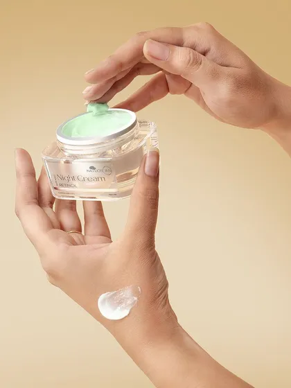 A hand applying a swatch of Natuos 365 Night Cream. Showing the product's texture on the skin is crucial for beauty and skincare e-commerce.