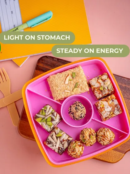 A vibrant kid's tiffin box filled with my wholesome snacks. These treats are light on the stomach and provide steady energy, making them a mom-approved choice for school lunches.