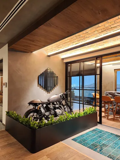 Another angle of the custom living partition we designed for a home in Hyderabad. It highlights the client's Triumph motorcycle as a style statement while functionally keeping it separate from the main living area.