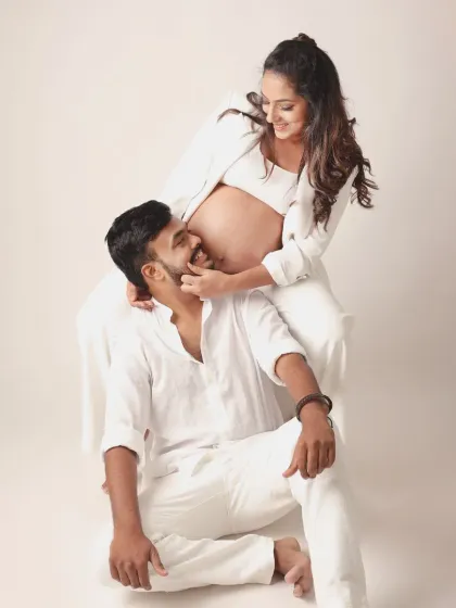 Playful, candid, and full of laughter. This couple's all white outfits create a fresh, modern look, and their joyful interaction makes for a truly heartwarming maternity photo.