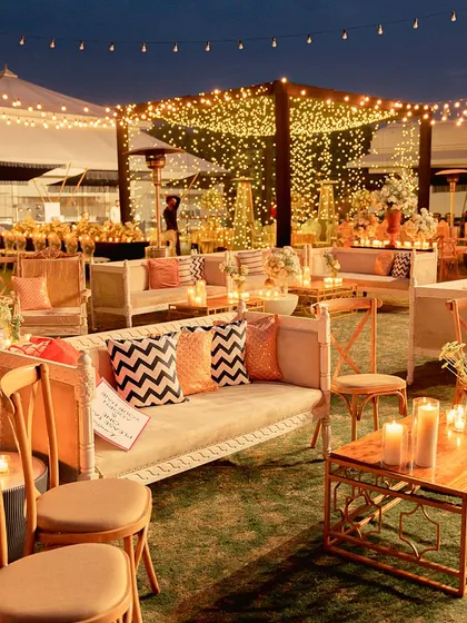 An inviting lounge area under a sky of fairy lights. We used comfortable sofas with modern-print cushions and warm candle lighting to create a perfect space for guests to relax and mingle.
