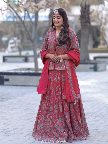 A full-length portrait of the bride in her beautiful pink lehenga, her smile radiating happiness.