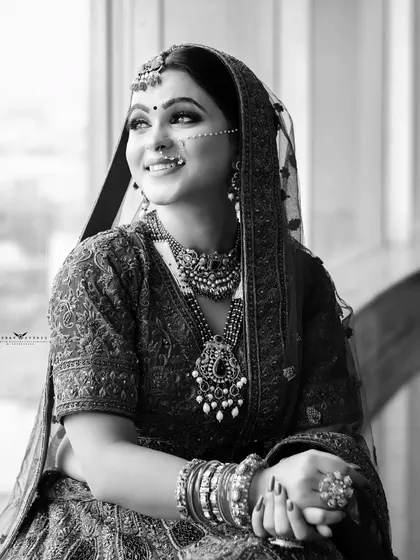 A black and white portrait of the bride by a window, creating a timeless and classic feel.