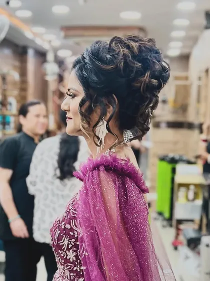 A side view of the party look, giving a better perspective on the sophisticated hairstyle and how it complements the neckline of the dress.