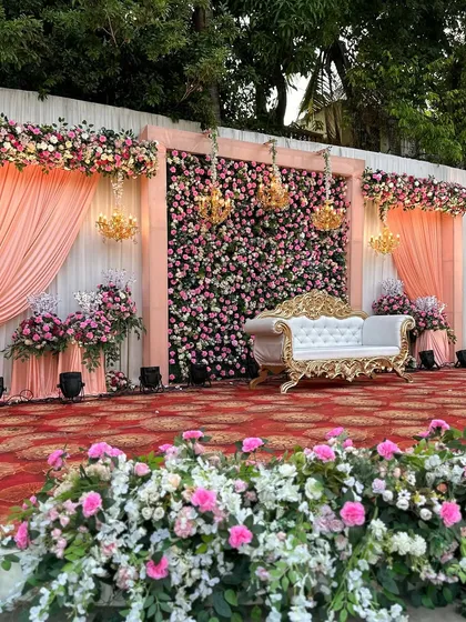 A close-up of the stage, focusing on the beautiful texture of the flower wall and the elegant chandeliers.