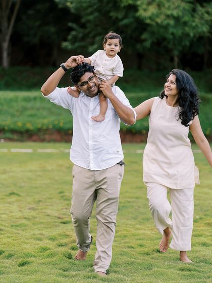 A family walking and laughing together in a park. These are the real, unposed moments that tell your story.