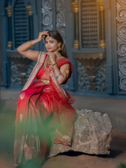 A full-shot of a student's work, creating a dreamy and dramatic South Indian bridal look in an outdoor setting.