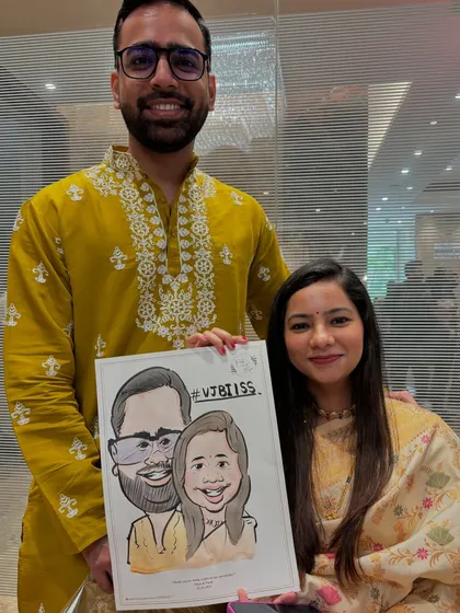 A couple poses with their caricature, which includes their wedding hashtag. It’s a fun way to celebrate their union.