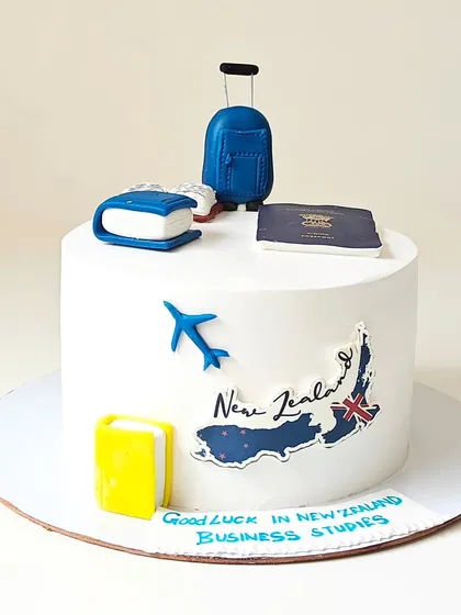 A "Good Luck" cake for someone moving to New Zealand for business studies. The design features a fondant passport, suitcase, and a map of New Zealand.