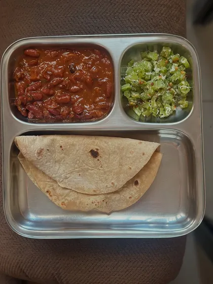 A simple lunch of chapati, rajma, and bitter gourd palya. This meal is a great example of a balanced, home-cooked Indian diet.