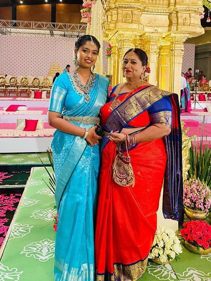 A picture of family and tradition. The rich colors of their Kanchipuram silk sarees are perfect for the grand wedding setting.