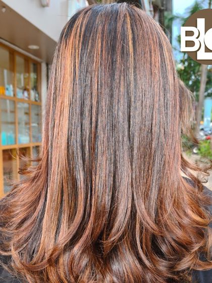 A gorgeous layered cut enhanced with warm, honey-toned highlights. The layers and color work together to create beautiful movement and texture.