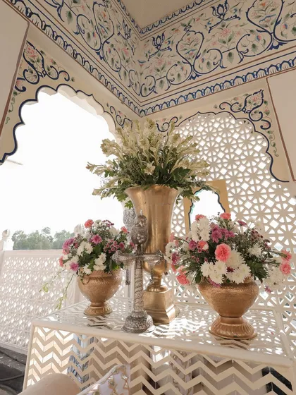 Details within the Baradari lounge, where pastel florals in golden vases were set against the backdrop of hand-painted walls and jali screens.