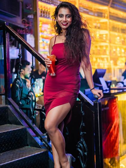 A guest in a red dress, posing on the stairs.