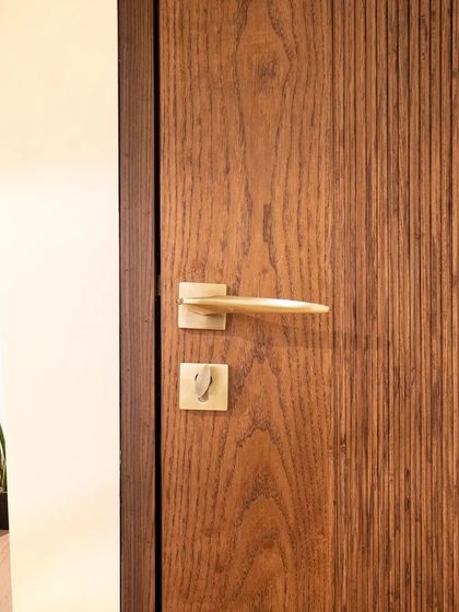 A minimalist wooden door with a subtle flute band, adding a touch of elegance and texture. The simple hardware completes the clean look.